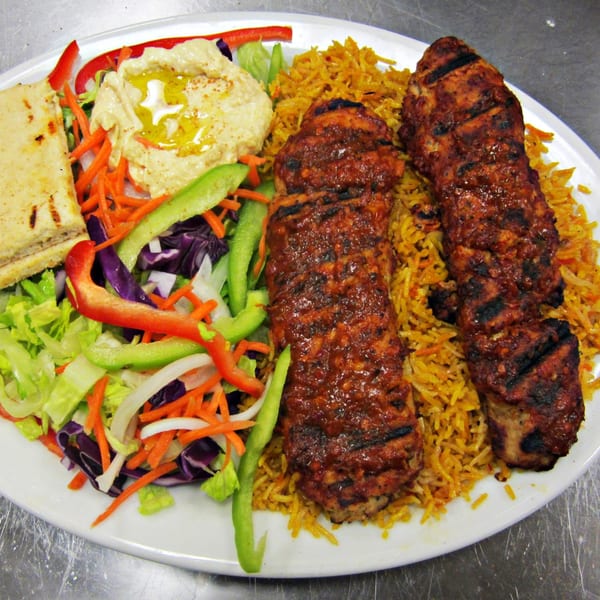 Maza Grill's halal chicken kebab plate with rice, hummus, pita bread, and fresh salad.