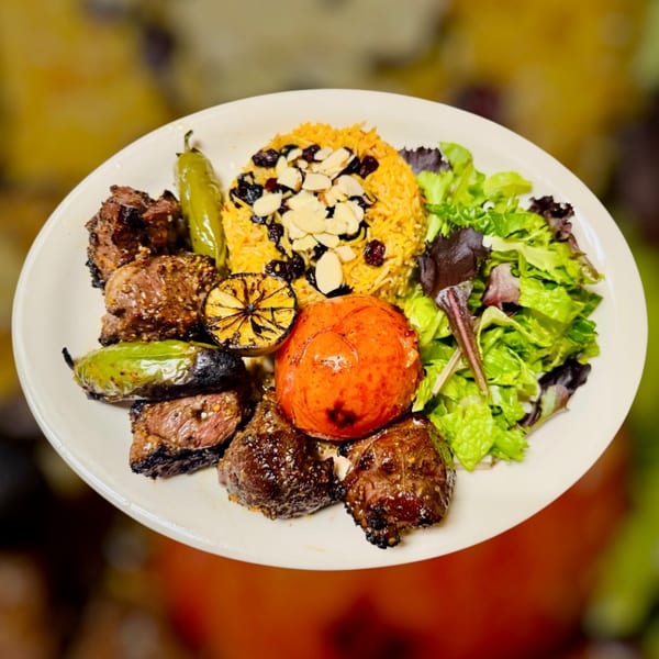 Halal Maza Grill plate with grilled meat, yellow rice, salad, roasted tomato, and peppers.