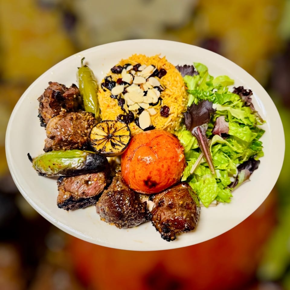 Halal Maza Grill plate with grilled meat, yellow rice, salad, roasted tomato, and peppers.