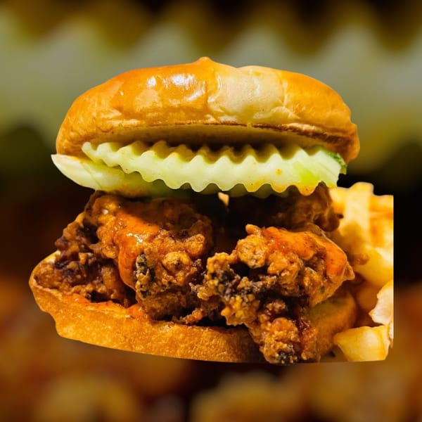 A Maza Grill halal fried chicken sandwich with pickles and waffle fries.